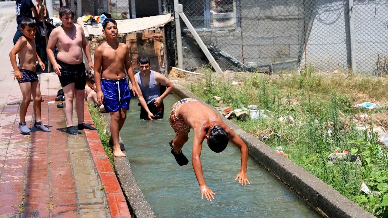 Adana’da Çocuklar Kaldırımda Güneşlenip Kanalette Serinliyor 2