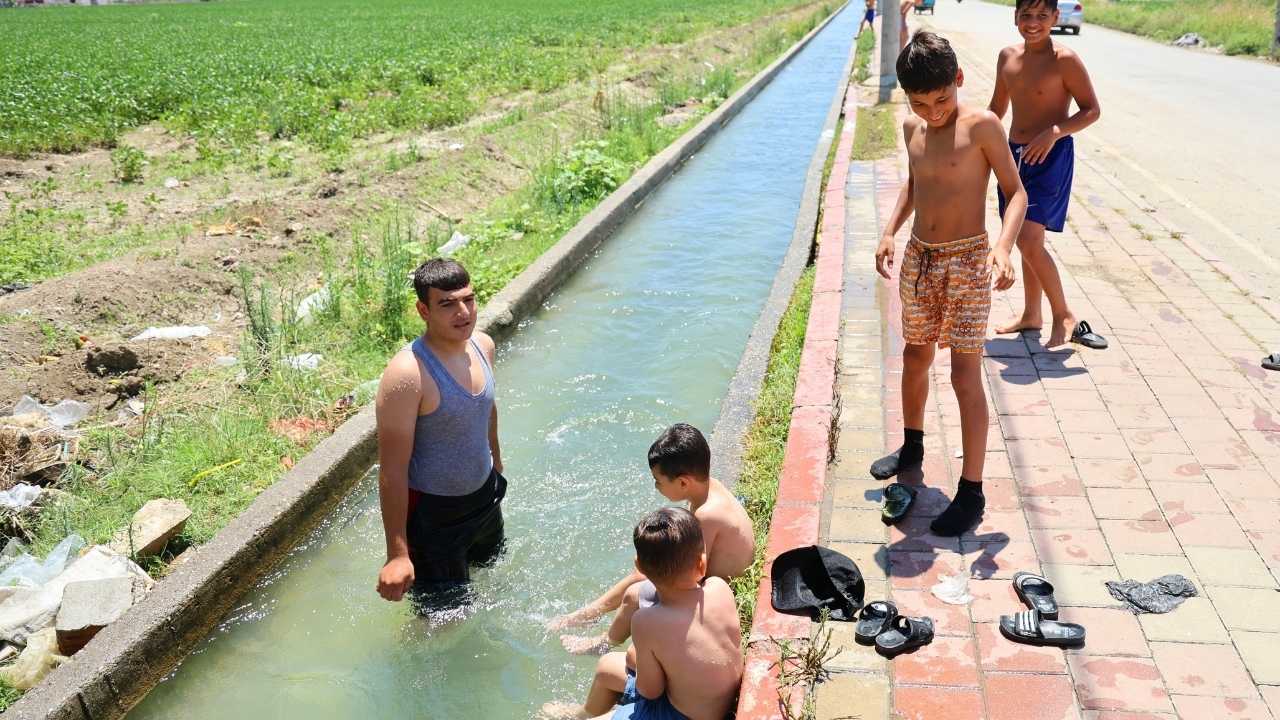 Adana’da Çocuklar Kaldırımda Güneşlenip Kanalette Serinliyor 3